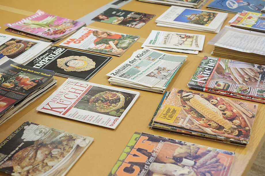 Bücher und Zeitschriften liegen verstreut auf einem Tisch.