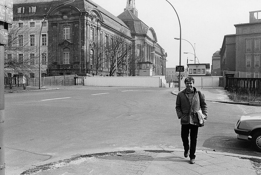 Schwarz-Weiß-Fotografie von Hansgert Lambers, die den Fotografen Christian Borchert am Grenzübergang Chausseestraße, Berlin 1988 zeigt.